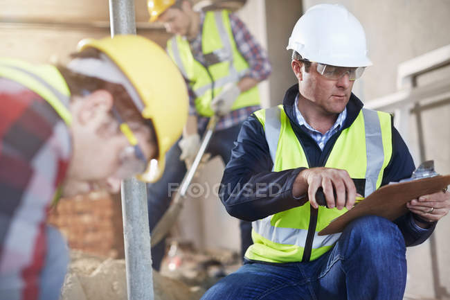 Foreman com prancheta no canteiro de obras — Fotografia de Stock