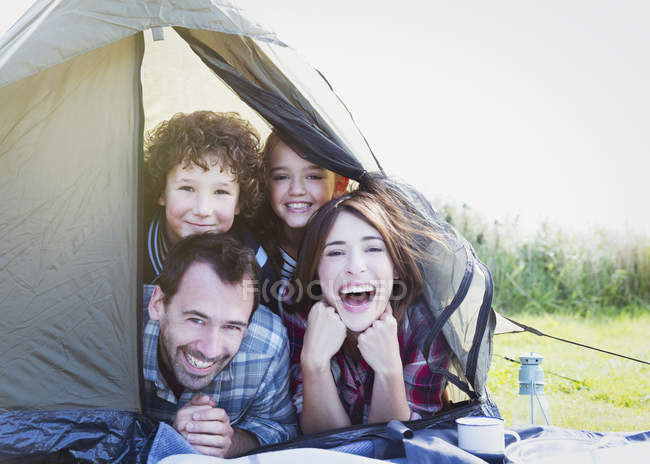 Портрет улыбающейся семьи в палатке — стоковое фото