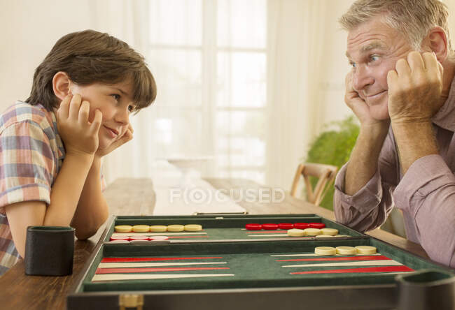 Abuelo y nieto jugando backgammon - foto de stock