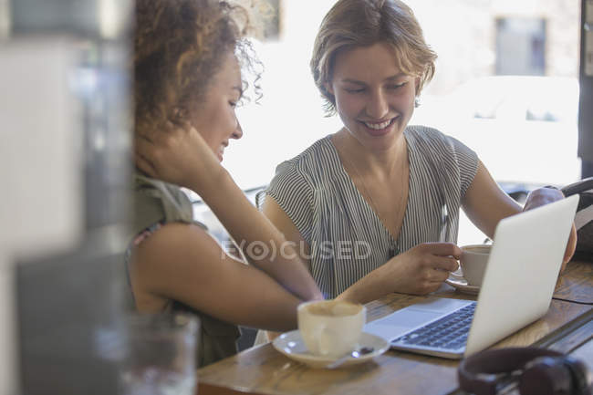Бізнес-леді з кавою, що працює на ноутбуці в кафе — стокове фото