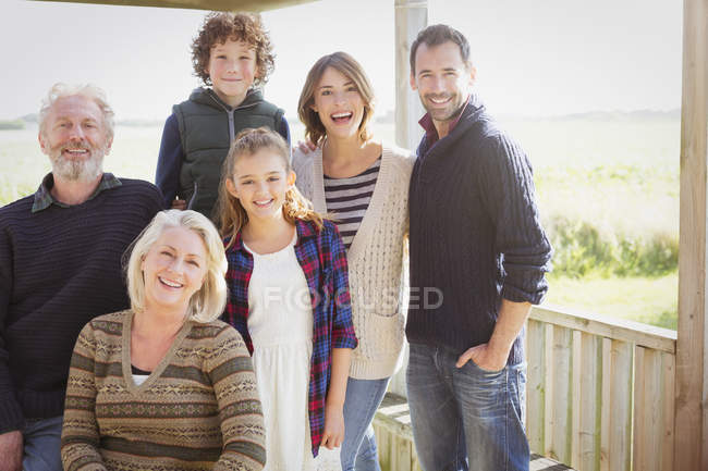 Портрет усміхненої сім'ї багато поколінь на сонячному ганку — стокове фото