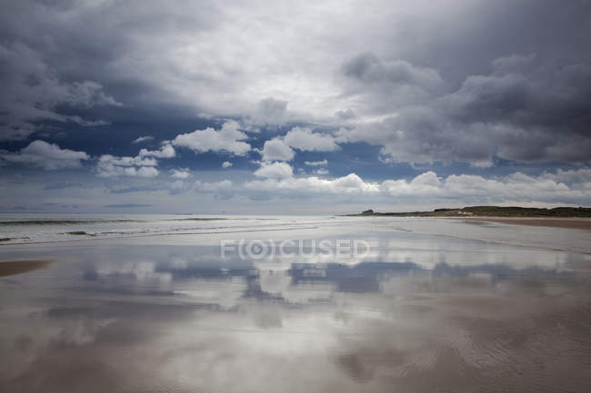 Reflection of clouds on beach at low tide — Stock Photo