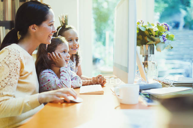 Mother and daughters using computer — Stock Photo