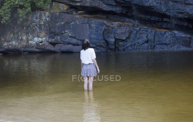 Femme pataugeant et regardant dans la piscine — Photo de stock