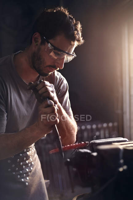 Blacksmith shaping tool in forge — Stock Photo