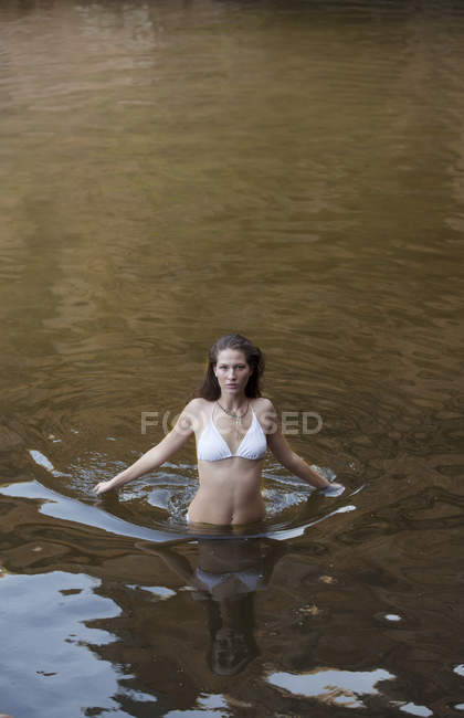 Donna guadare nel fiume durante il giorno — Foto stock