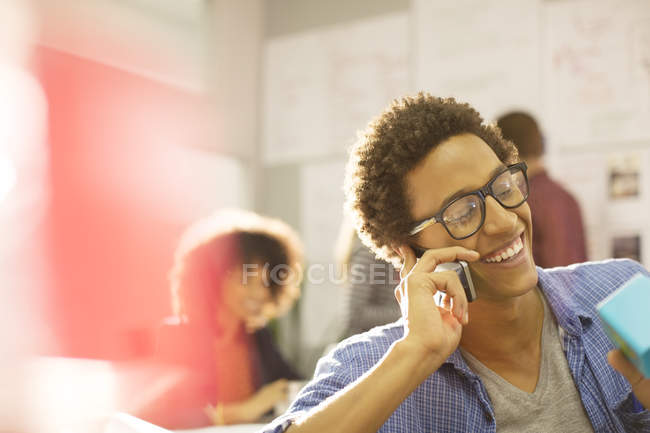 Businessman talking on cell phone in office — Stock Photo