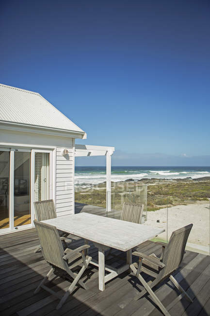 Стол и стулья на патио с видом на пляж — стоковое фото