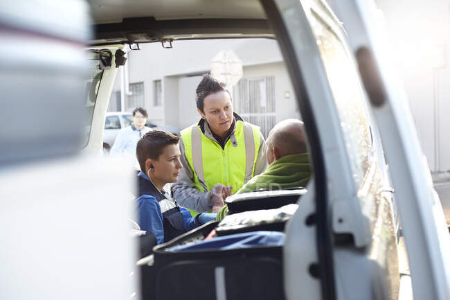 Rescue workers talking at back of ambulance — Stock Photo