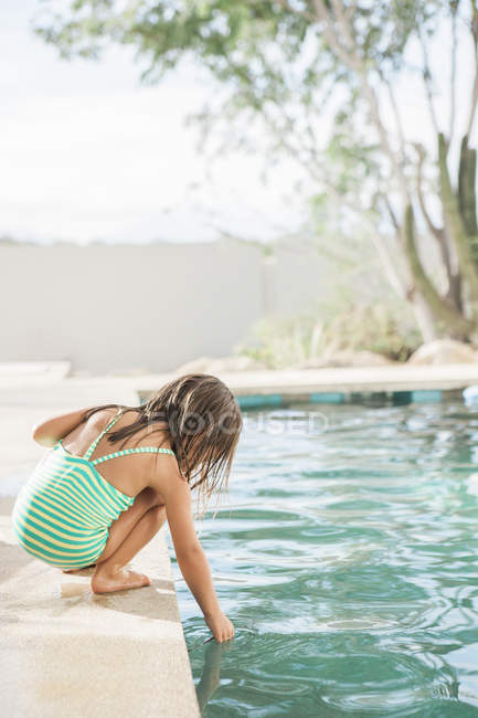 Дівчина Тоддлер тестує воду на краю басейну — стокове фото