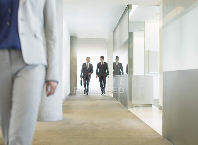 Hommes d'affaires marchant dans le couloir du bureau — Photo de stock