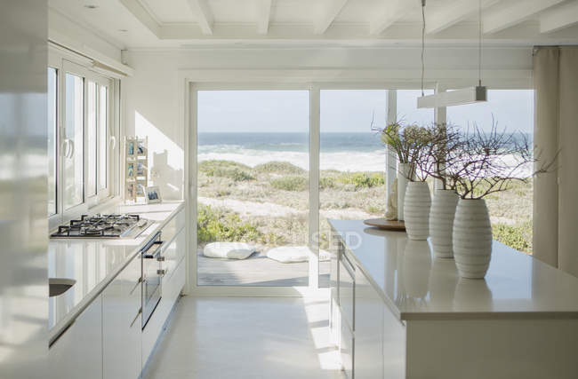 Modern white kitchen with ocean view — Stock Photo