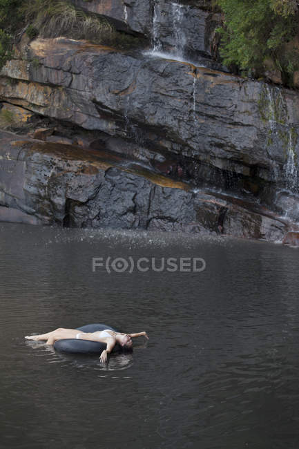 Frau schwimmt in Schlauch auf Fluss — Stockfoto
