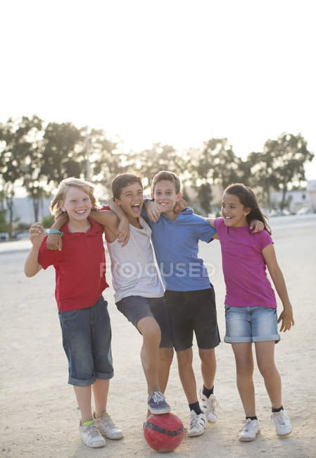Enfants jouant avec le ballon de football dans le sable — Photo de stock