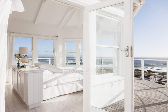 Scenic view of white bedroom overlooking ocean — Stock Photo