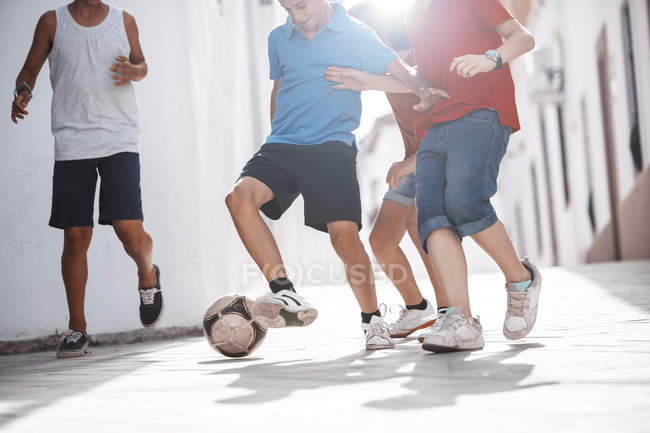 Crianças brincando com bola de futebol no beco — Fotografia de Stock