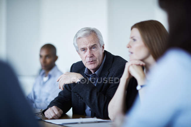 Homme d'affaires supérieur à l'écoute en réunion — Photo de stock