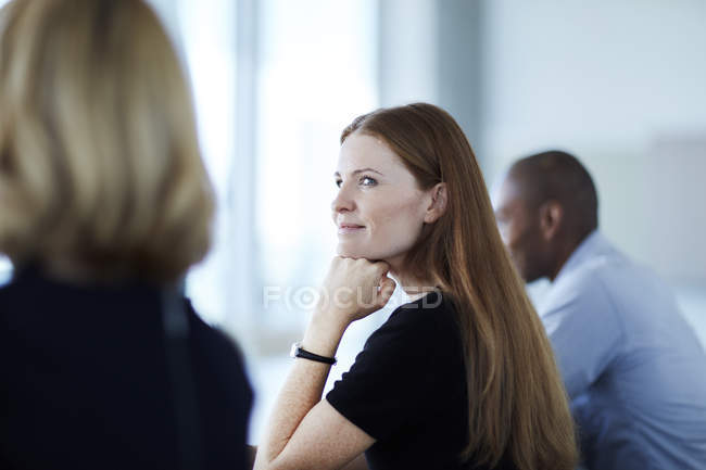 Уверенная деловая женщина слушает во время встречи — стоковое фото