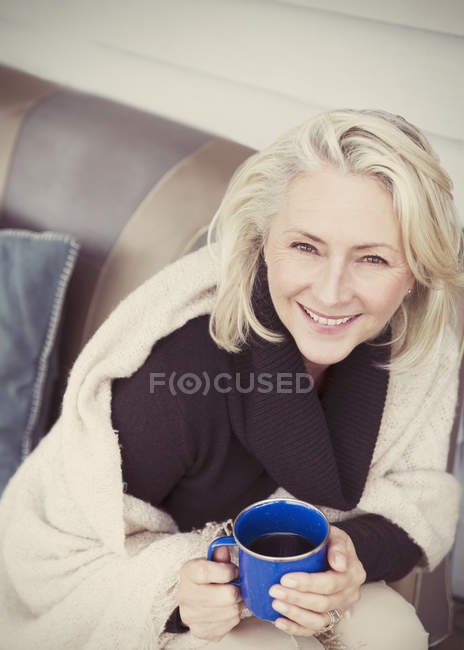 Portrait femme âgée souriante portant châle boire du café sur le patio — Photo de stock
