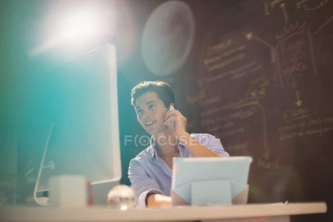 Uomo d'affari che parla al telefono in ufficio moderno — Foto stock