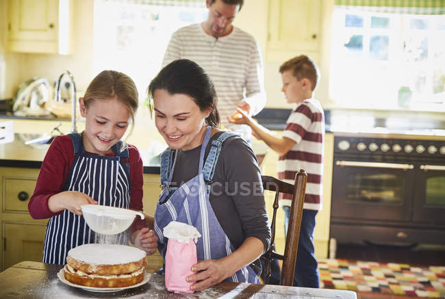 Семья на кухне в помещении, готовит еду и торт — стоковое фото