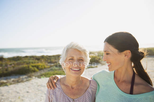 Mother and daughter on sunny beach — Stock Photo