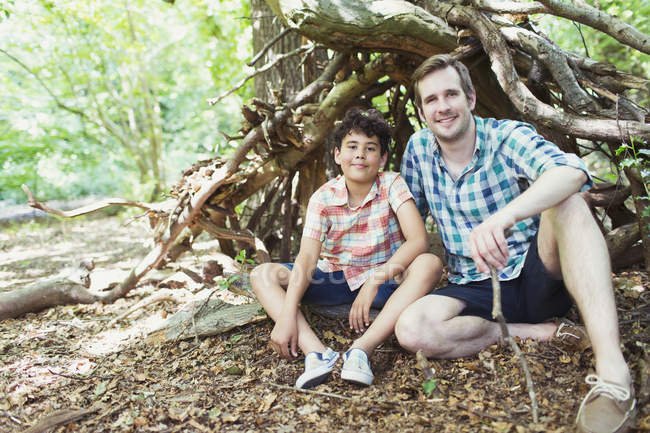 Портрет улыбающихся отца и сына в лесу — стоковое фото