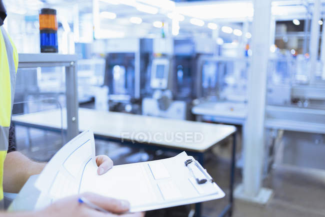 Close up worker with clipboard in factory — Stock Photo