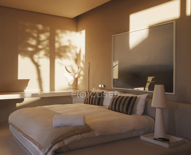 Reflection of trees on wall in modern bedroom — Stock Photo
