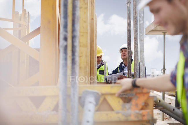 Foreman with digital tablet looking up at construction site — Stock Photo