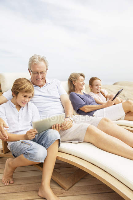 Großeltern und Enkel nutzen digitale Tablets am Pool — Stockfoto