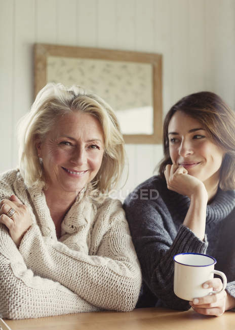 Portrait smiling mother and daughter in sweaters drinking coffee — Stock Photo