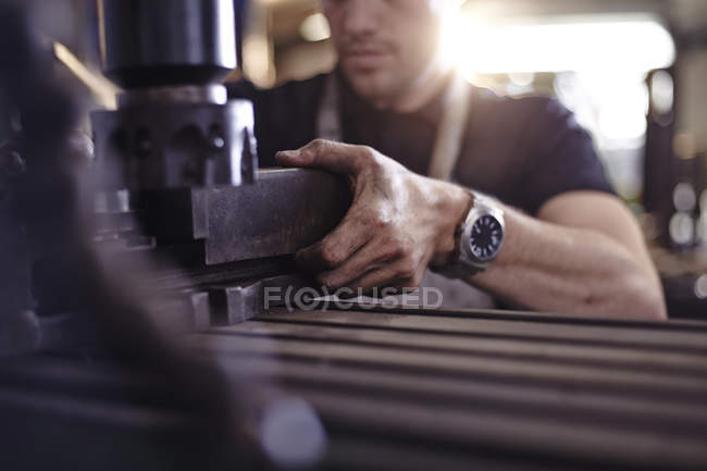 Primer plano mecánico utilizando maquinaria en taller de reparación de automóviles - foto de stock