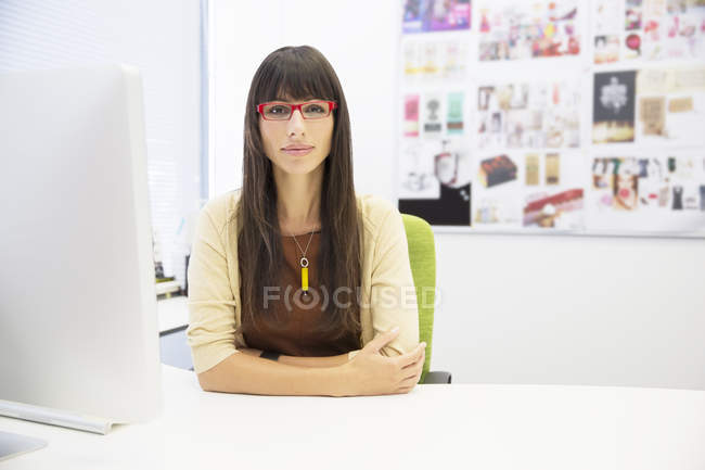 Portrait of businesswoman sitting at desk in office — Stock Photo