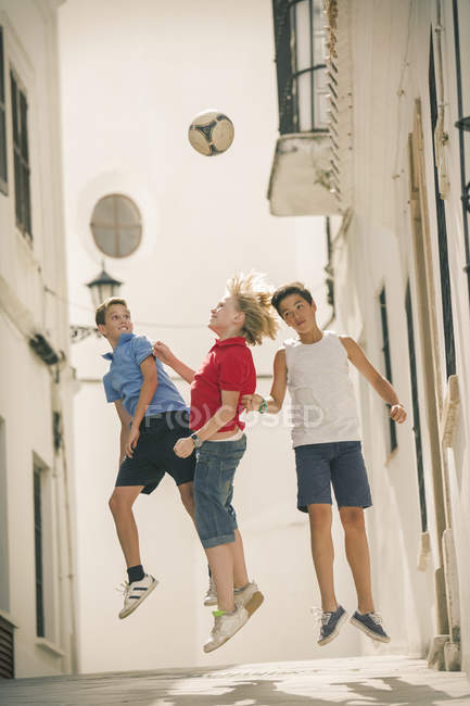 Дети играют в футбол в переулке — стоковое фото