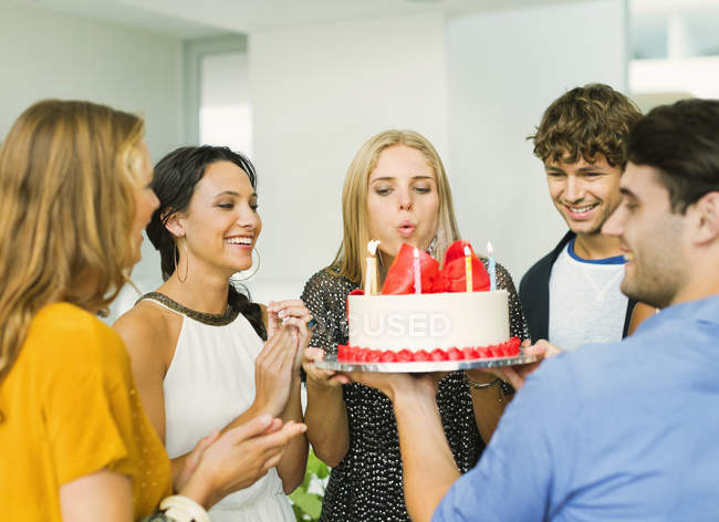 Woman blowing out candles on birthday cake — Stock Photo