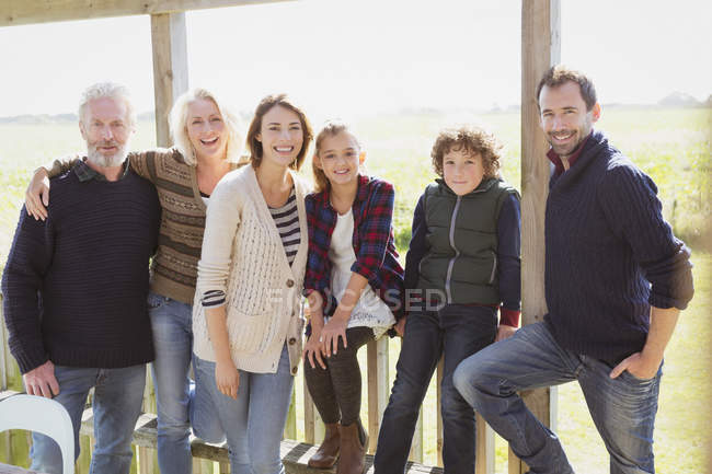 Retrato sonriente familia multi-generación en porche soleado - foto de stock