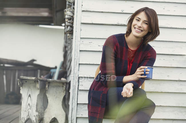 Ritratto sorridente bruna donna che beve caffè sul portico — Foto stock