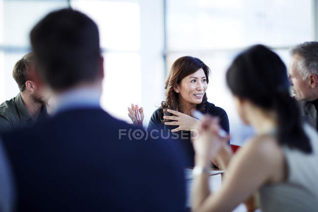 Успешные взрослые бизнесмены разговаривают на встрече — стоковое фото