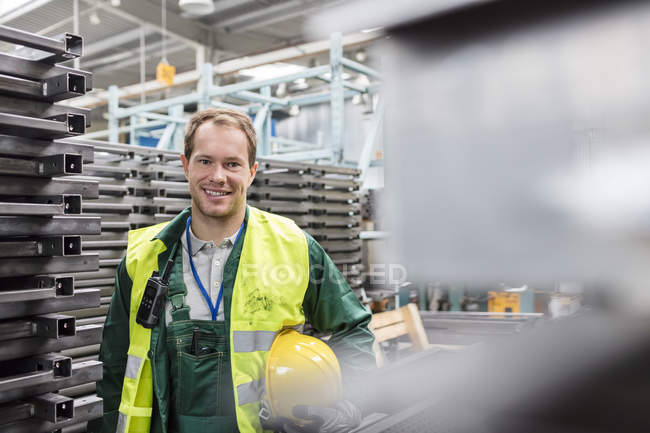Портрет улыбающегося рабочего в защитной рабочей одежде на сталелитейном заводе — стоковое фото