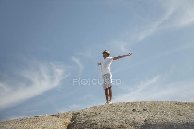 Uomo in piedi sulla formazione rocciosa — Foto stock