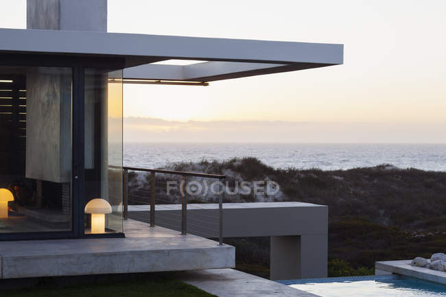Maison moderne avec vue sur l'océan au coucher du soleil — Photo de stock