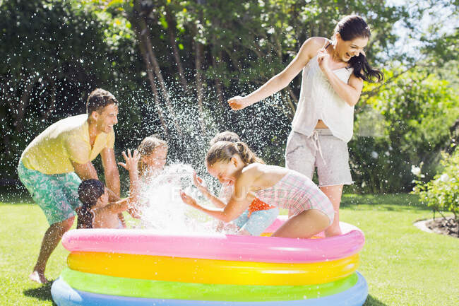 Família brincando juntos na piscina — Fotografia de Stock