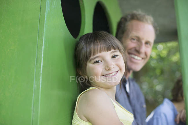 Счастливые отец и дочь улыбаются в домике на дереве — стоковое фото