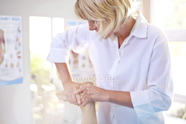 Fisioterapeuta masaje paciente pie - foto de stock