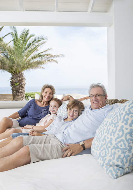 Older couple with grandchildren on sofa — Stock Photo