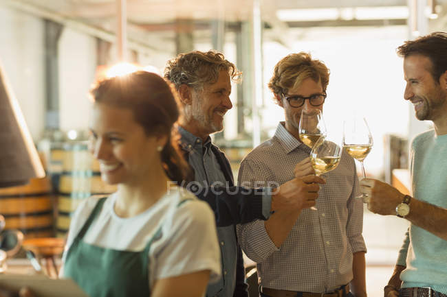 Homens degustação de vinhos brancos na sala de degustação da adega — Fotografia de Stock