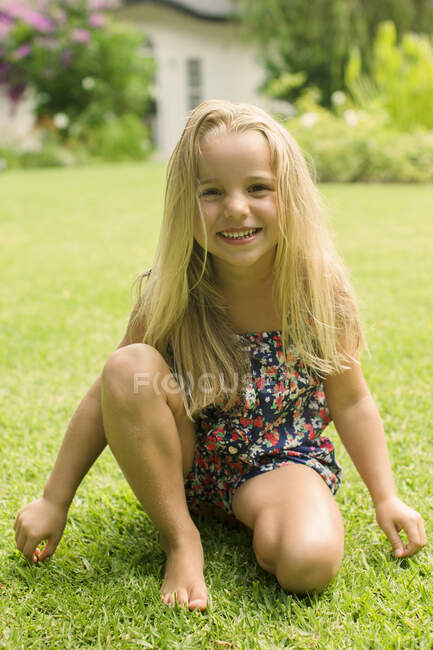 Mädchen lächelt im Hinterhof über Gras — Stockfoto