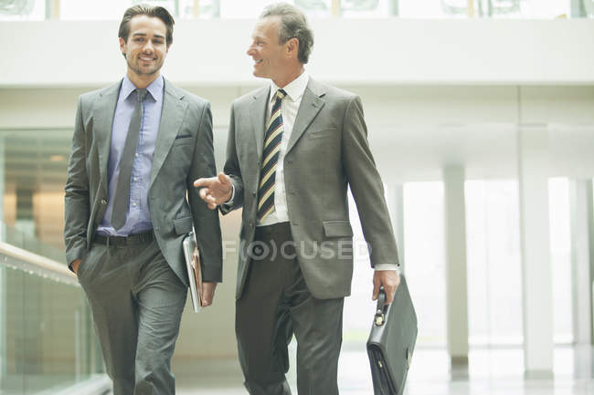 Businessmen talking in office lobby — Stock Photo