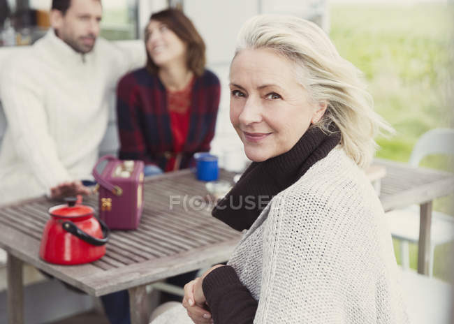 Retrato sorrindo mulher idosa na mesa do pátio — Fotografia de Stock